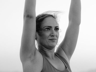 Woman hands doing stretching exercises in dark blue light